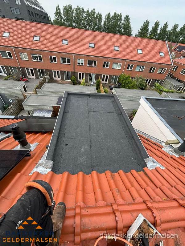 Bitumen dak reparatie op plat dak tussen dakpannen in Geldermalsen