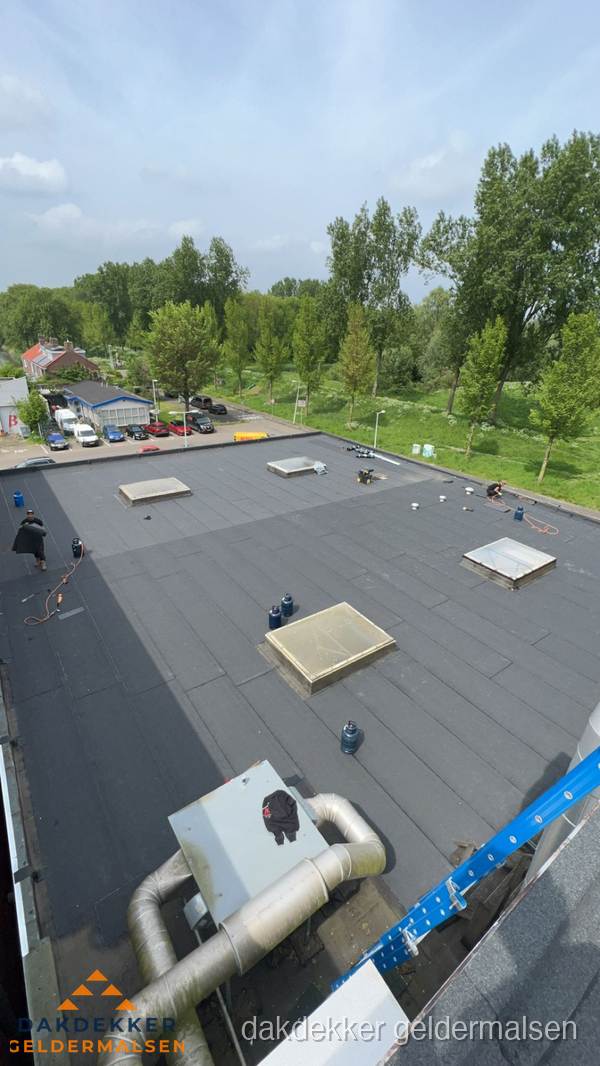 Dakdekker aan het werk op groot plat dak met bitumen in Geldermalsen Dakdekker aan het werk op groot plat dak met bitumen in Geldermalsen