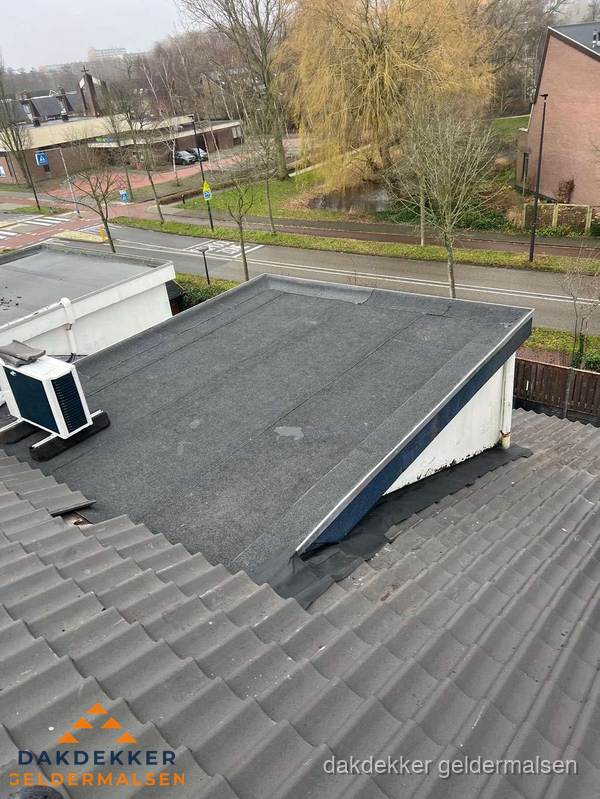 Plat dak met bitumen dakbedekking naast schuin pannendak in Geldermalsen