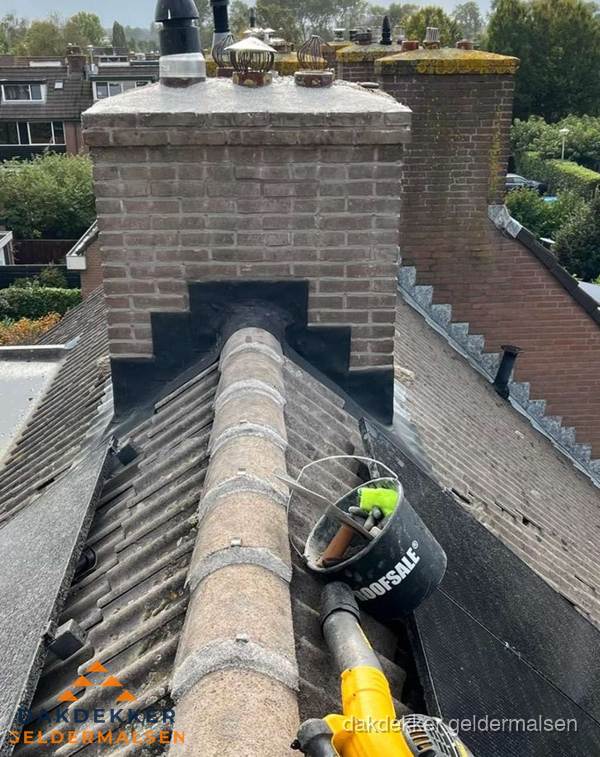 Schoorsteen met loodaansluiting en nokvorst op pannendak in Geldermalsen