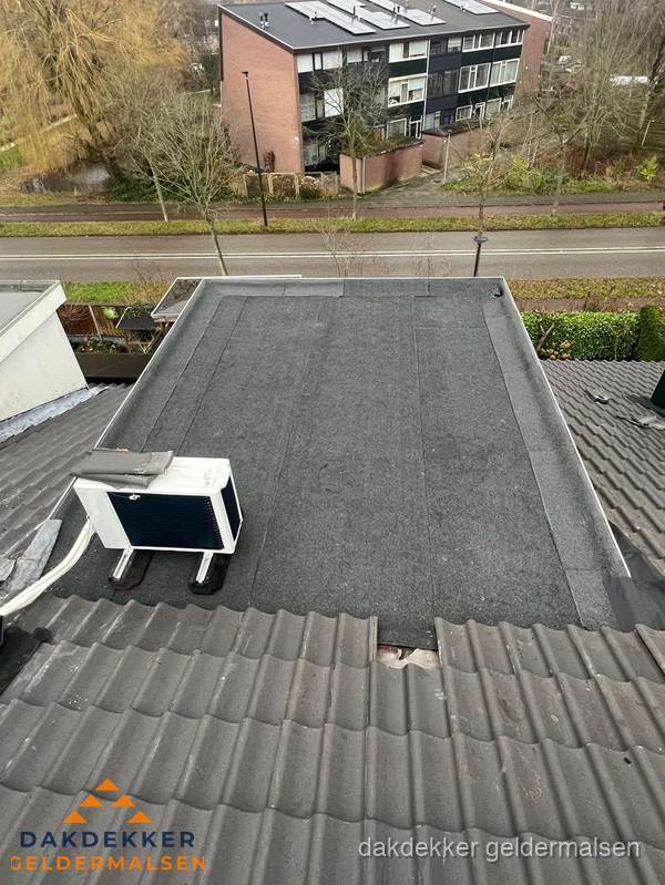 Plat dak inspectie met bitumen bedekking naast schuin pannendak in Geldermalsen
