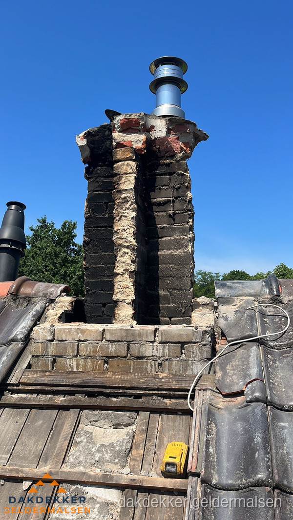 Beschadigde schoorsteen met nieuwe rookgasafvoer op oud dak in Geldermalsen
