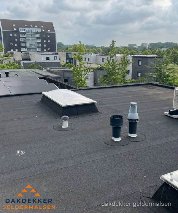 Groot plat dak met lichtkoepel en dakdoorvoeren in Geldermalsen