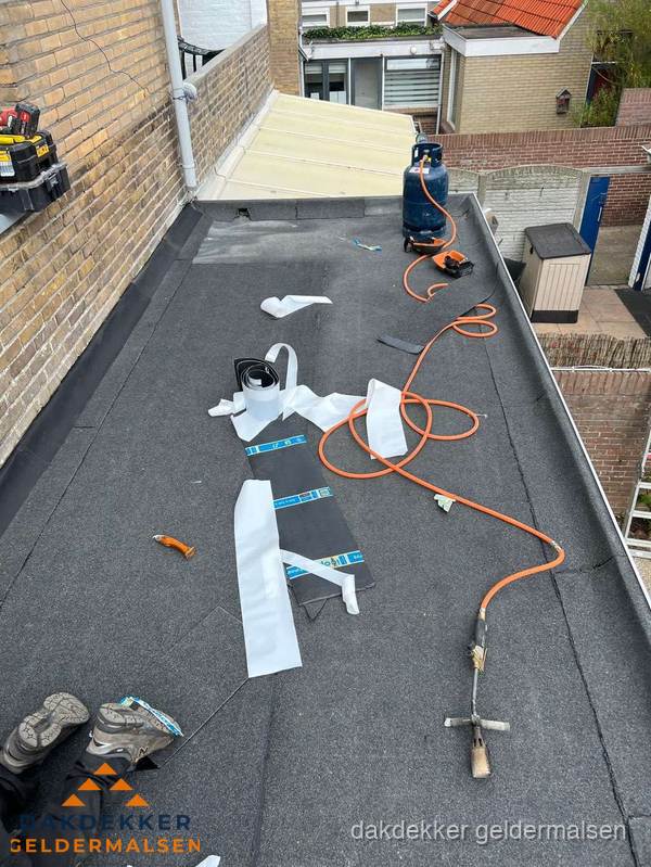 Dakdekkers bezig met bitumen dakbedekking in Geldermalsen