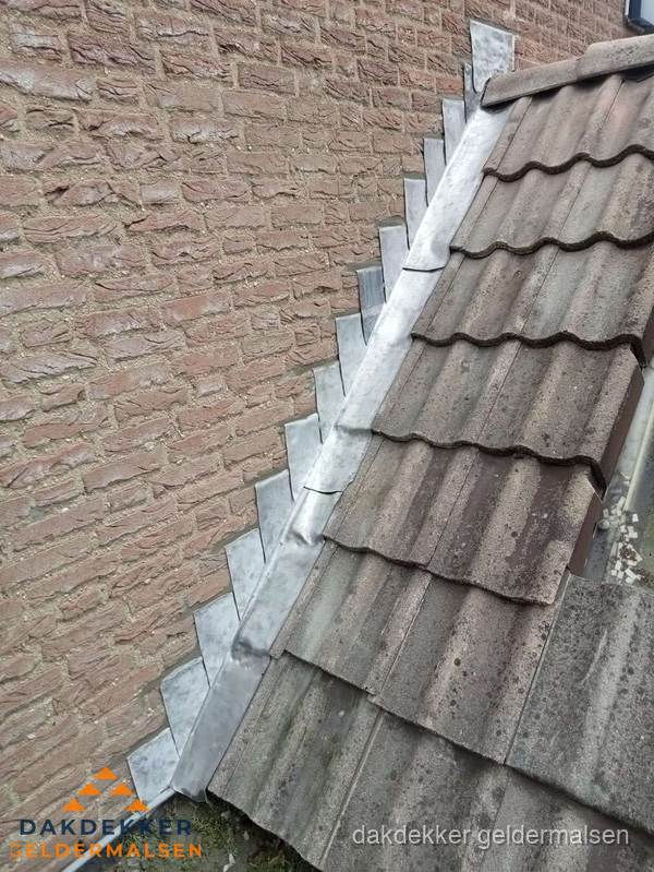 Loodslabben langs dakaansluiting bij bakstenen muur in Geldermalsen